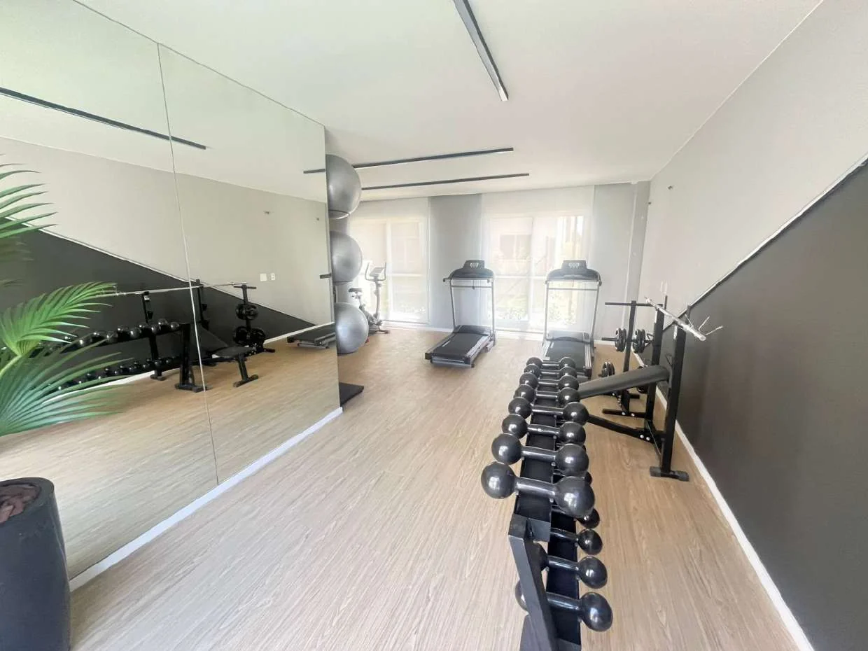 Halteres e espelhos na academia do Nova Irajá, em foto real.
