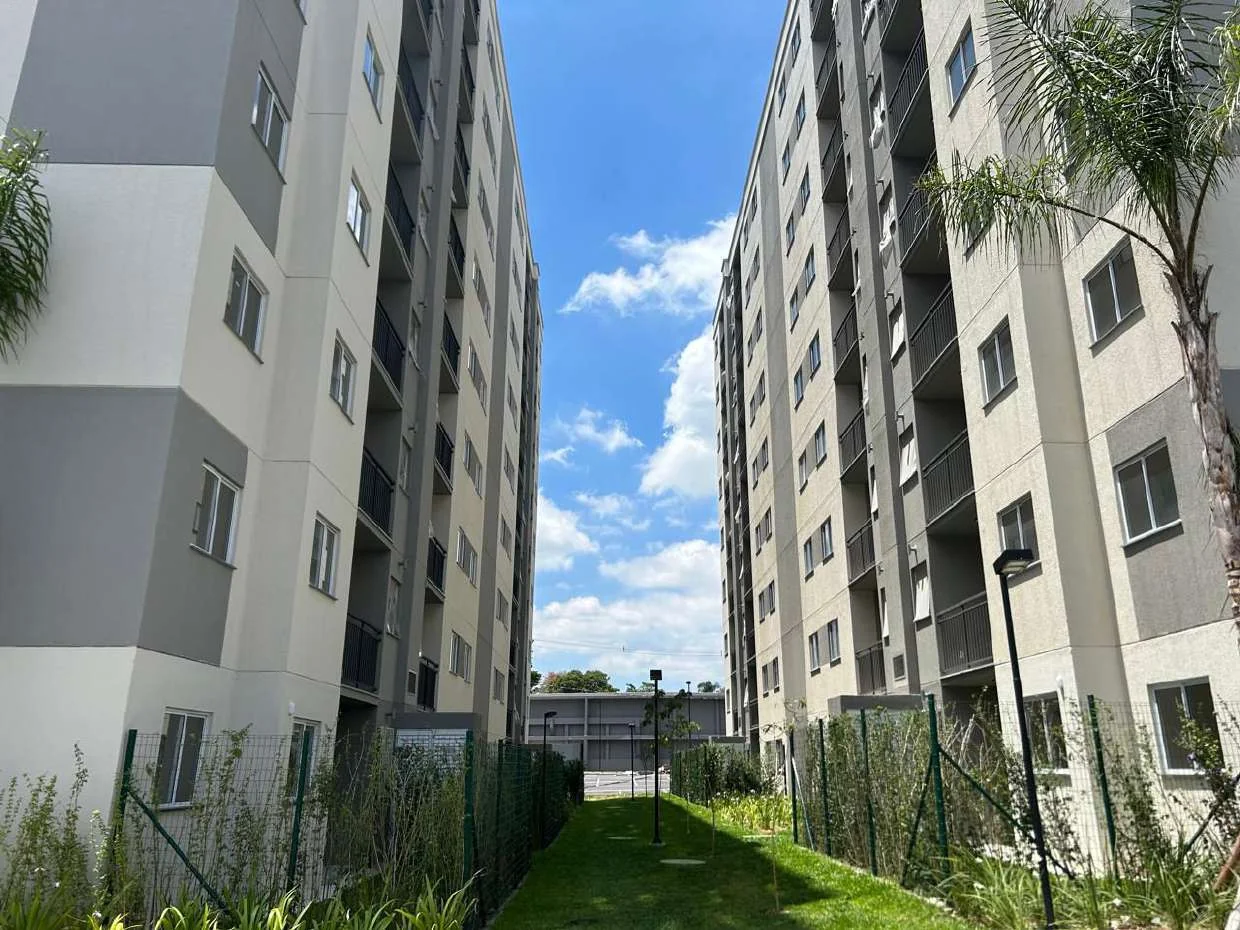 Caminho ajardinado entre os blocos do Nova Irajá, em foto real.