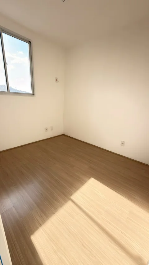 Quarto com janela e piso amadeirado no apartamento visitado