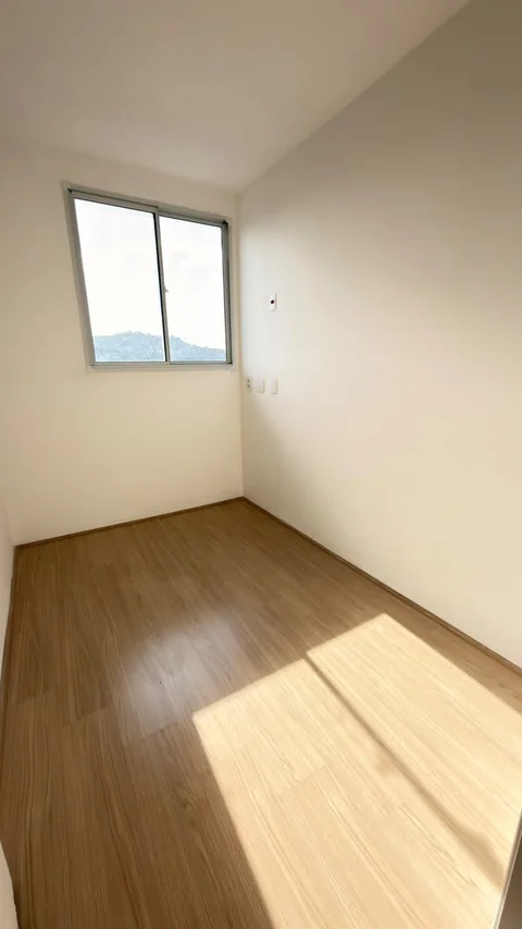Quarto claro com janela ampla no apartamento visitado